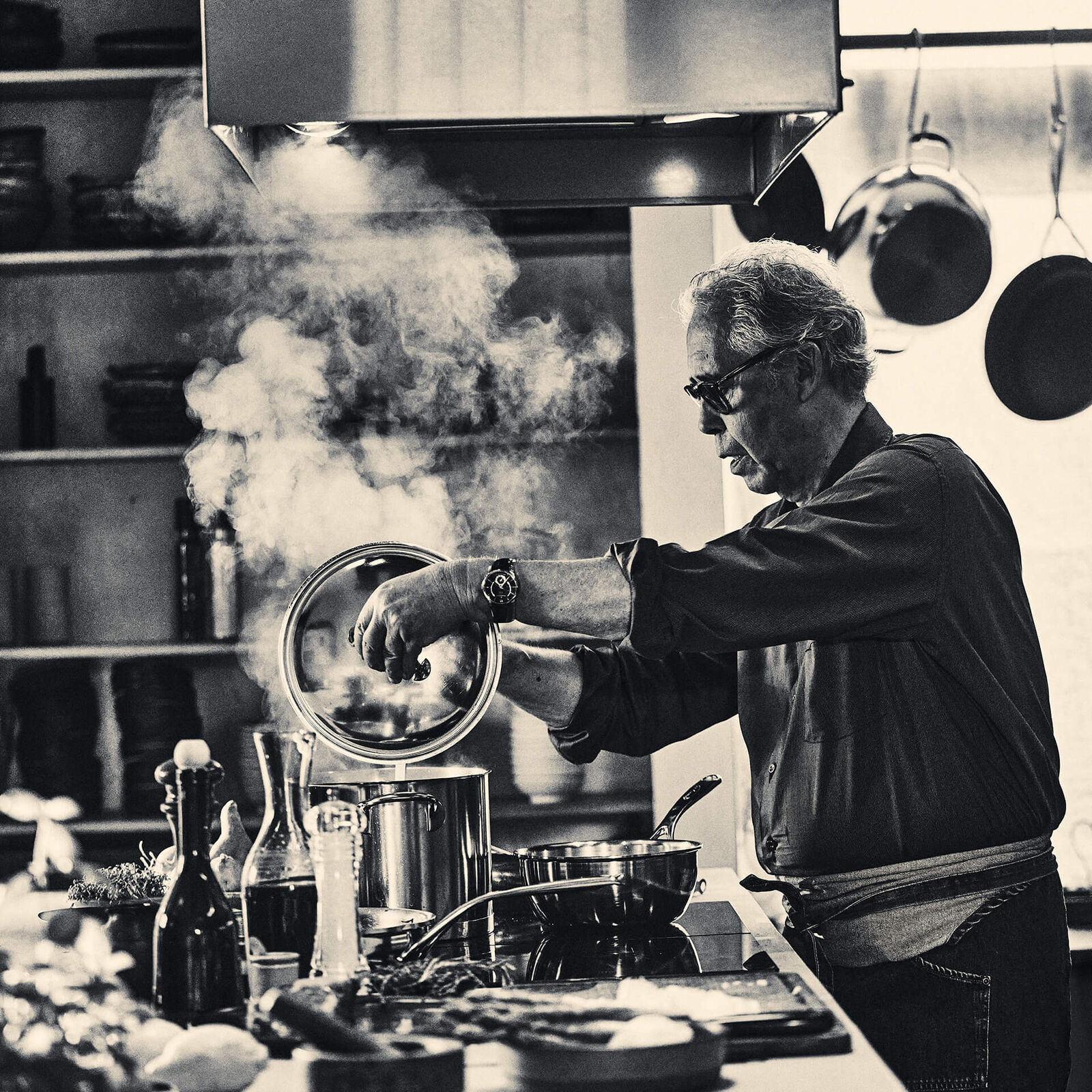 Demeyere stainless steel pots and pans photographed in a dark atelier setting